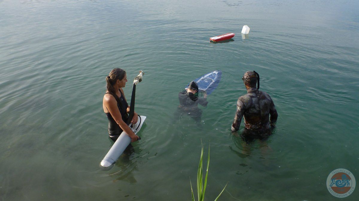 Drei Taucher bereiten sich im Wasser auf den nächsten Wettkampf vor